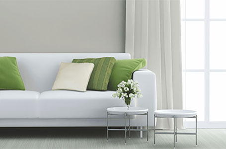 White couch with green pillows and a coffee table